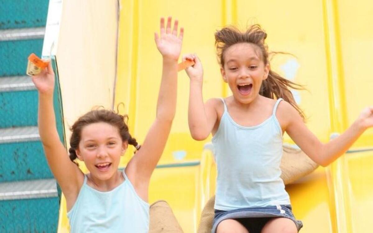 
Abby Byer, 8, left, and Brianna Wesselmann, 8, both of Mascoutah, hold up their hands as the go down the slide at the 2014 Old Fashioned July 4th Celebration at Sheve Park in Mascoutah. 
