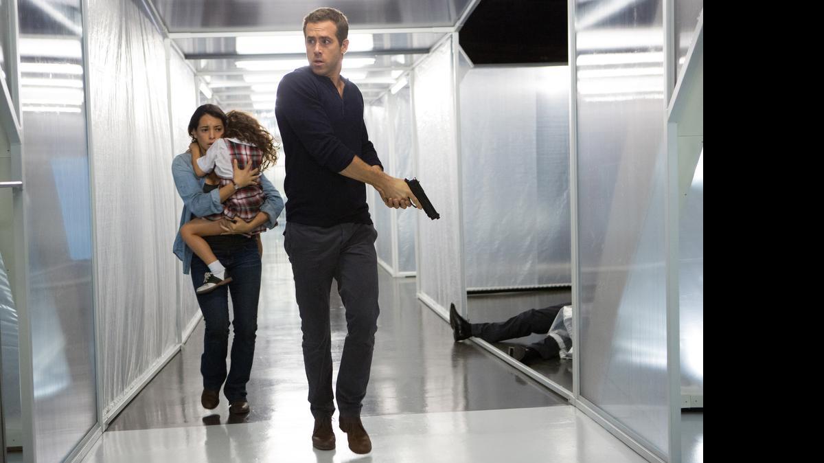 
Natalie Martinez, left, and Jaynee-Lynne Kinchen flee with Ryan Reynolds in a scene from the psychological science fiction thriller "Self/less." 

