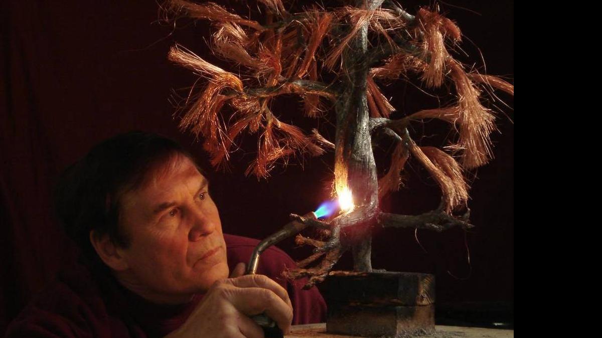 
Artist Wayne Tricklein works on his tree sculpture.
