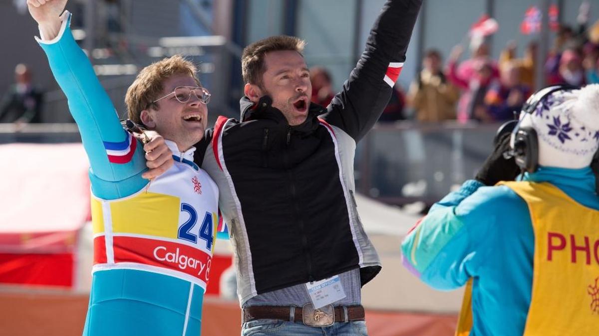 Taron Egerton, left, and Hugh Jackman celebrate in a scene from “Eddie the Eagle.”(Larry Horricks/20th Century Fox via AP)