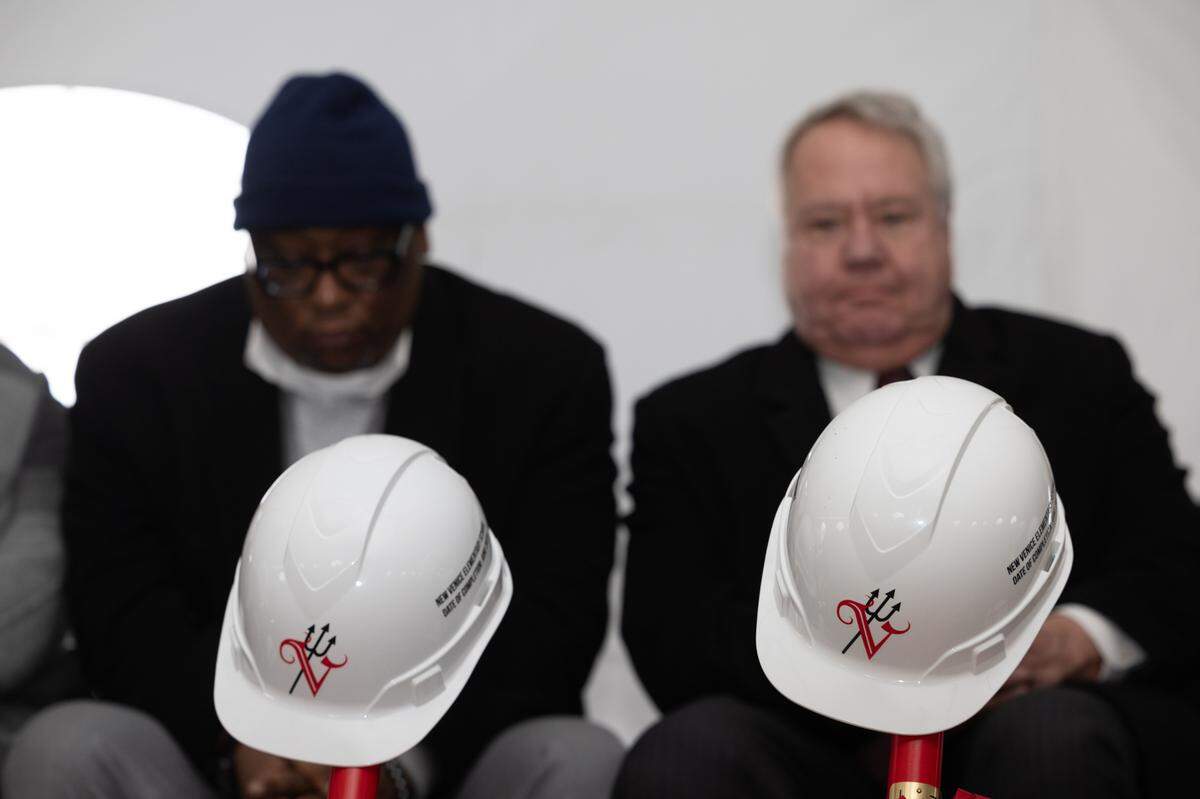 State Sen. Christopher Belt, D-Swansea, and Rep. Jay Hoffman, D-Swansea, sit behind hard hats adorned with the Venice District 3 logo at the groundbreaking ceremony for the city’s new elementary school on Feb. 16, 2024, in Venice, Ill.