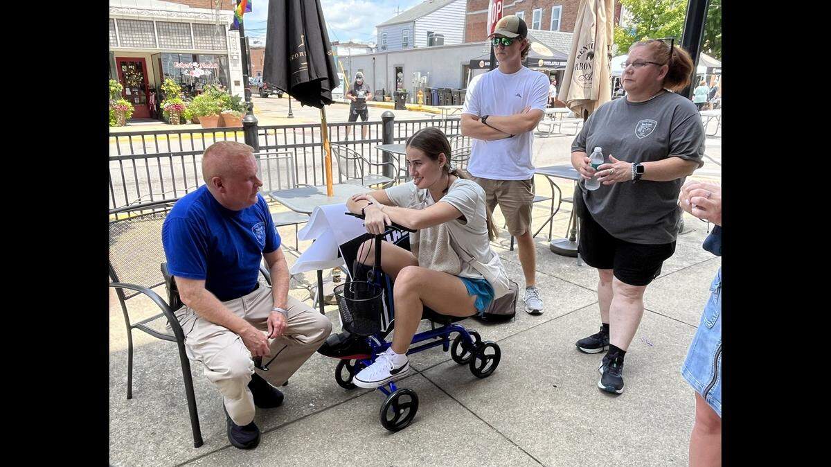 Injured Fairview Heights police officer Molly Muennich, center, talks to Police Chief Steve Johnson at a Rock the Blue fundraiser on Saturday in Belleville as her fiance, Devon Rathbun, and police volunteer Jen Knepper look on.