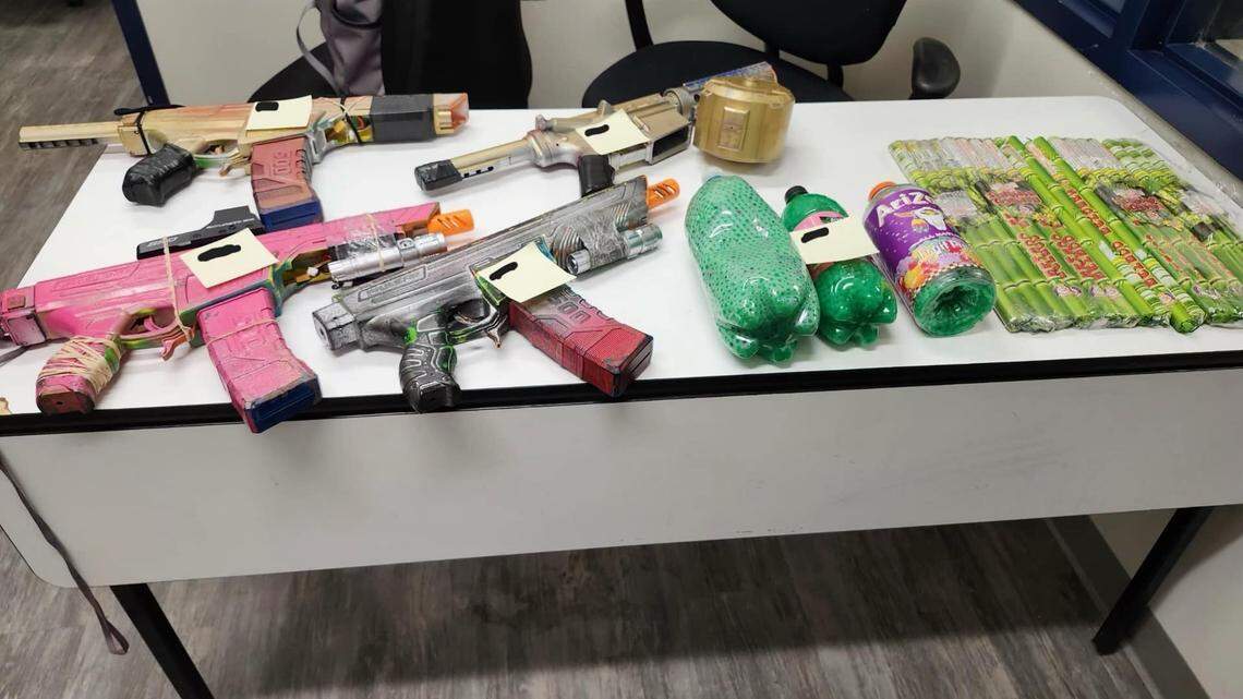 A police evidence table shows four gel blasters, bottles of soda containing water beads and roman candles.