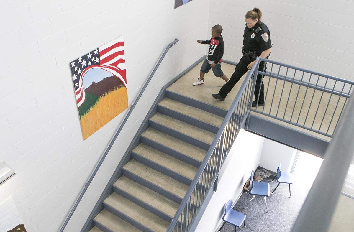 High Mount School first-grade student Malcolm Graham walks with school resource officer Cheryl Venorsky.