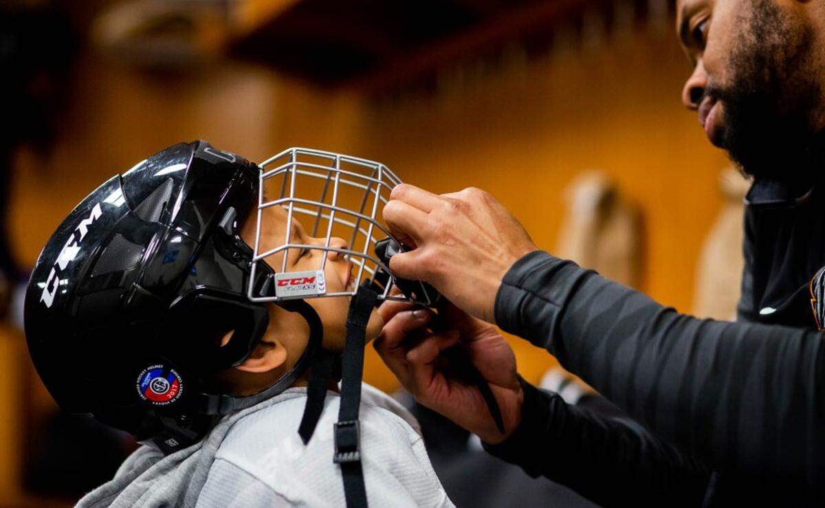 Daxton Shanks, 4, of north St. Louis, reacts as his father, David Shanks, adjusts his helmet March 9 before a North City Blues practice at Enterprise Center.