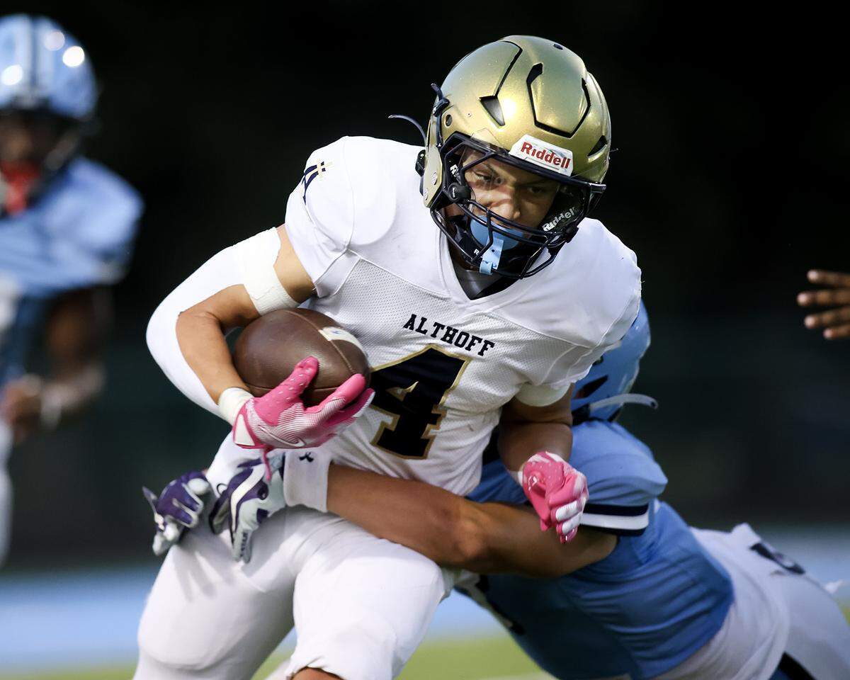 Althoff's Steven Brown carries the ball during Friday night’s intracity matchup between the Crusaders nd Belleville East.