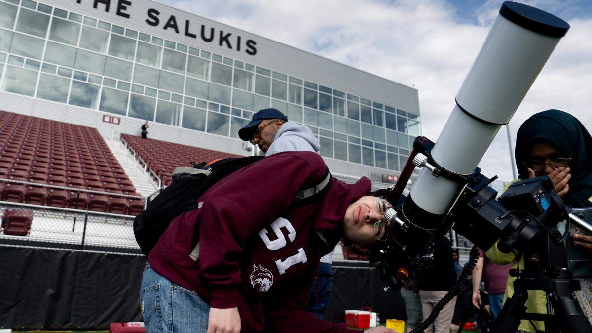 Noah Ross, 25, of Little Rock, Ark., focuses a telescope ahead of the total solar eclipse on Sunday, April 7, 2024, at Saluki Stadium in Carbondale, Ill.