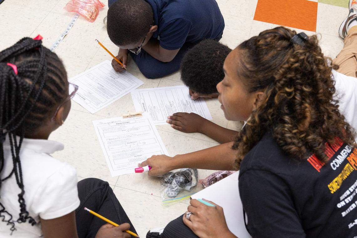 A teacher helps students with group math exercises at Avant Elementary School in Washington Park, Ill., on Oct. 8, 2024.