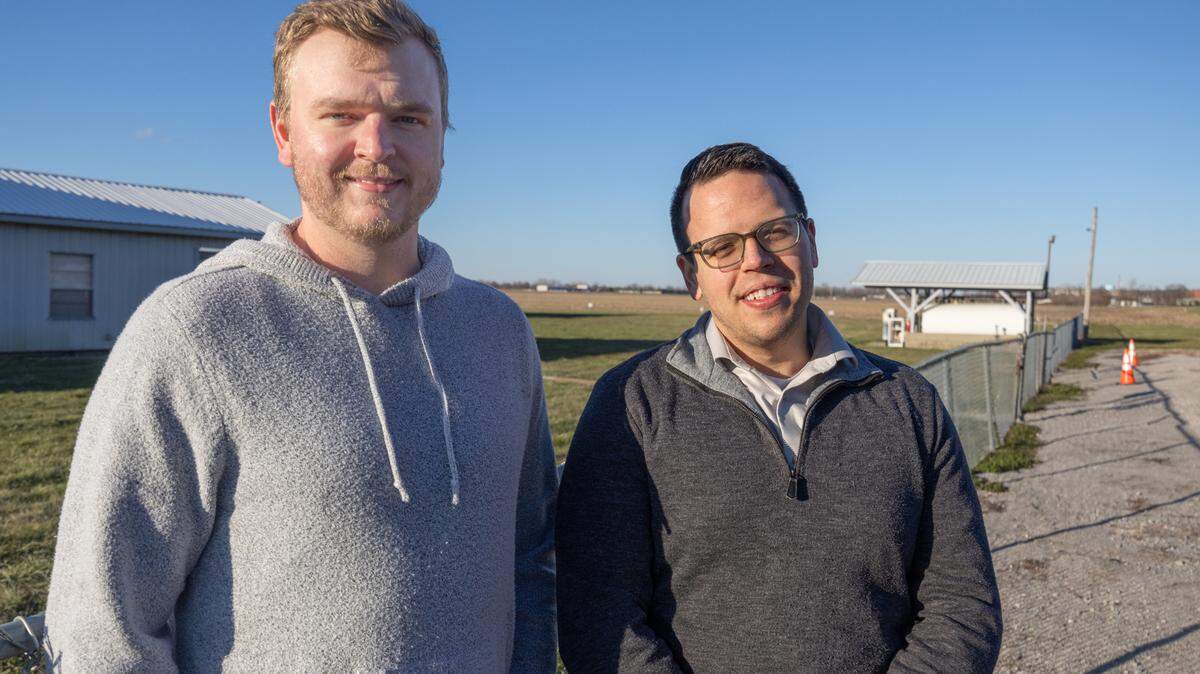 Clayton Poindexter, left, and Mark Amoroso stand besides a Monroe County airfield, where a plane departed on Sunday and crashed in a nearby farm field. Poindexter and Amoroso rescued the pilot from the wreckage.