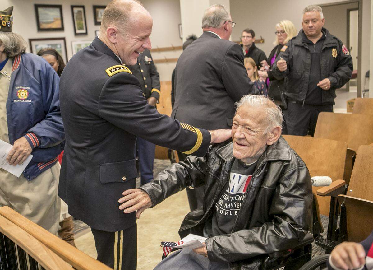 Army Gen. Stephen R. Lyons, commander of U.S. Transportation Command, speaks with World War II Army Air Corps veteran Fred Bruss, 95, on Monday. Lyons gave Bruss a USTRANSCOM coin and thanked him for his service. Bruss was shot down three times over Italy during his service. Bruss is also a retired Belleville fire chief.
