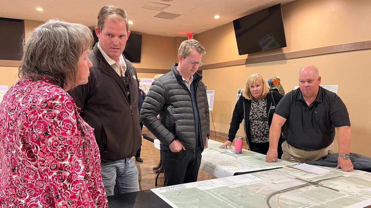 Tiffany Brase, studies and plans engineer for the Illinois Department of Transportation, left, listens to concerns from Josh and Jake Newman and their parents, Pam and Joe Newman, at a public hearing Tuesday in East St. Louis on the proposed Illinois 3 and 203 connector.