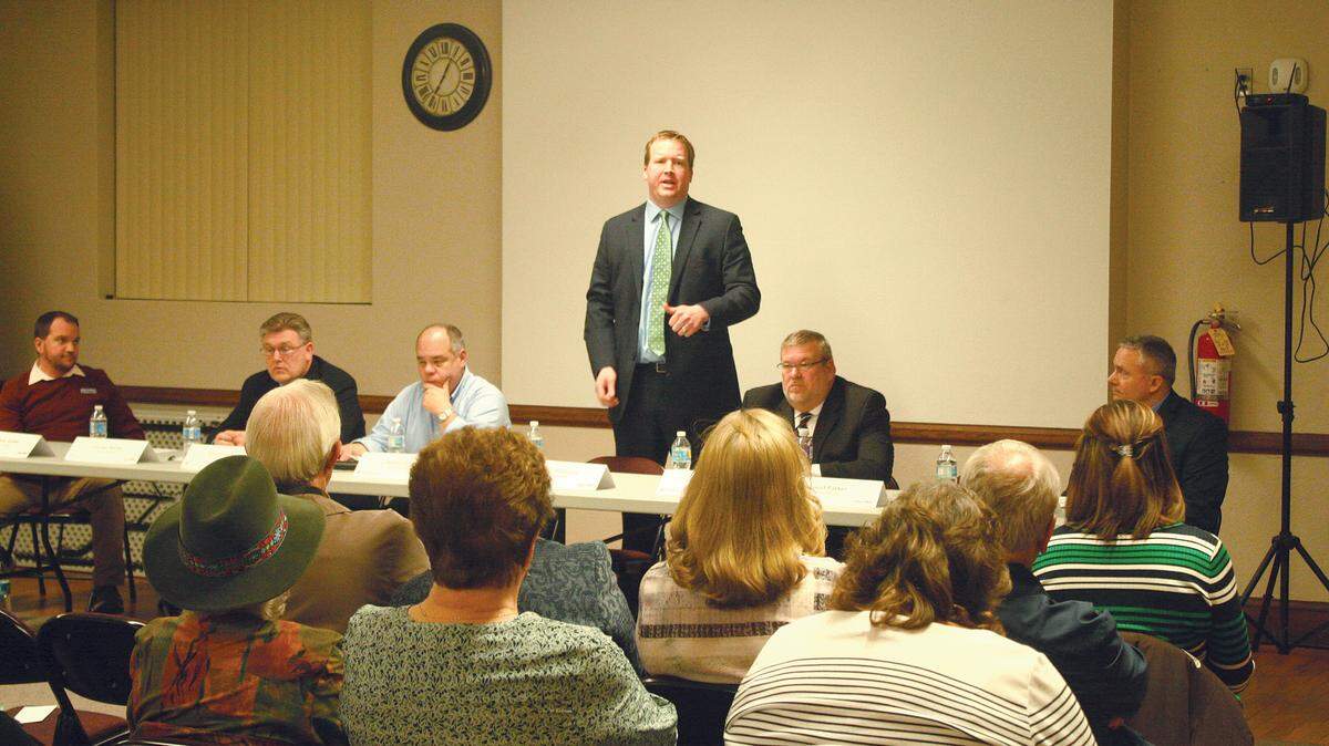 Jason Plummer, a candidate for the Illinois Senate in the 54th District, stands to speak at candidate forum at Latzer Library in Highland on Monday. The event was sponsored by the Highland Chamber of Commerce and Highland Jaycees. Also pictured, seated from left, are Kevin Gaither, who is running for Congress in the 15th District; George Barber, candidate in the 54th Illinois Senate District; Ben Stratemeyer; candidate in the 54th Illinois Senate District; Rafael Him, candidate in the 54th Illinois Senate District; state Rep. Charlie Meier, incumbent in the 108th Illinois House District; and Don Moore, who is running against Meier in the 108th District.