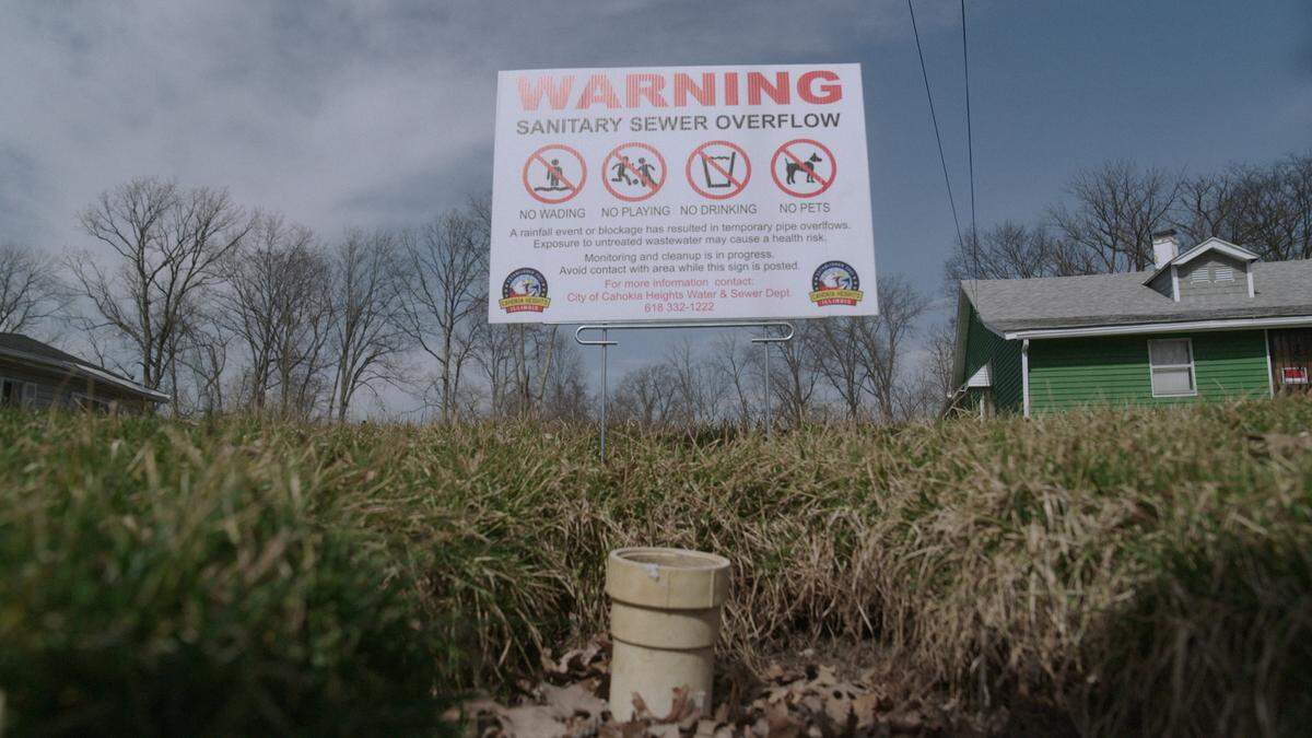 A sign by William McNeal’s house warns that there is a sanitary sewer overflow and warns residents of potential health risks if exposed to the contaminated water.