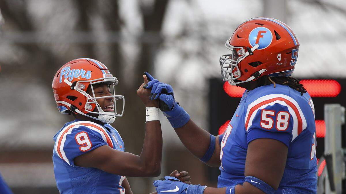 East St. Louis’ Robert Battle and Miles McVay celebrate an opening drive touchdown run during the IHSA Class 6A quarterfinals.