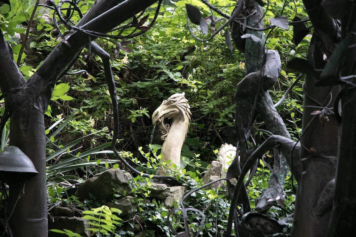Sculptures peak through the leaves in the secret garden behind the Rainmaker studio in Makanda.