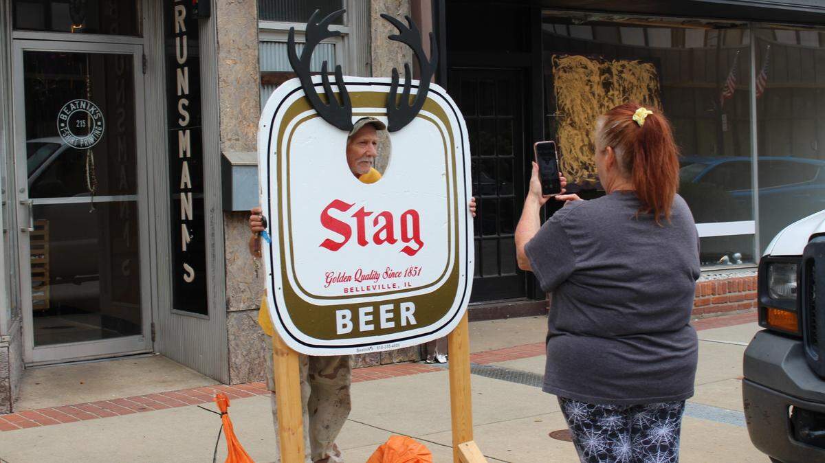 Tina Hofmeister takes a photo of her boyfriend, John Vahlkamp, putting his face into a photo board outside Beatnik’s in downtown Belleville. The T-shirt shop specializes in Stag beer clothing.