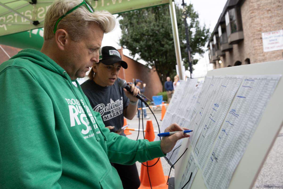 Emcees take a tally as runners cross the finish line at the Belleville Marathon on Sept. 28, 2024.