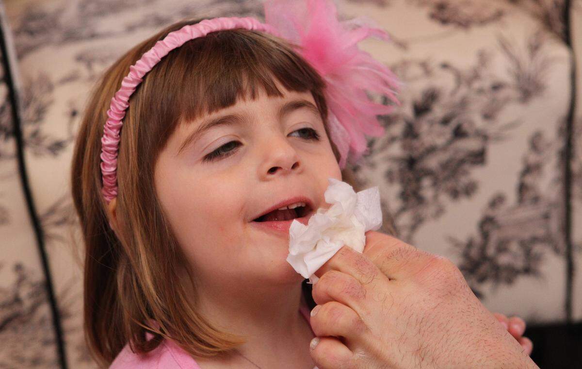 John Foppe wipes crumbs off the face of his daughter, Faith.