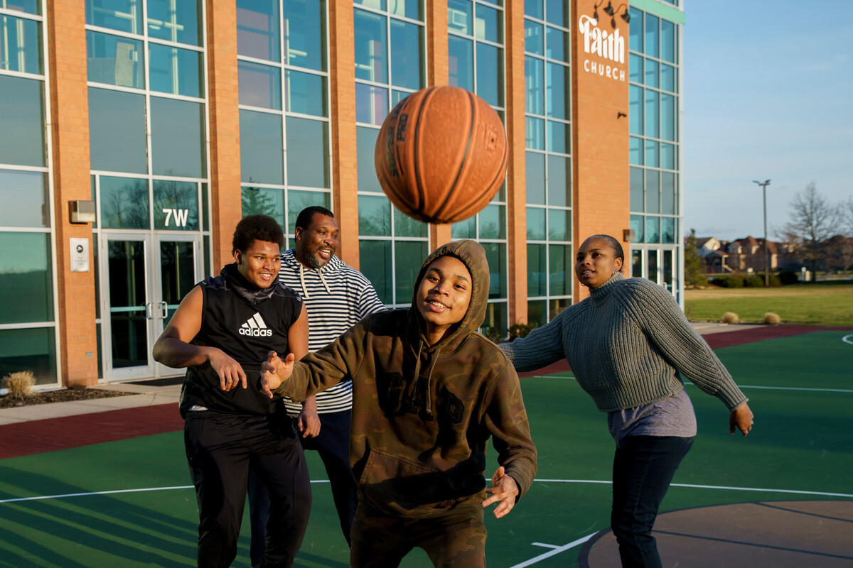 Josiah and Jeremiah, at left and right-center, play basketball at a church near their home with their parents, Rodney and Elizabeth Posley.