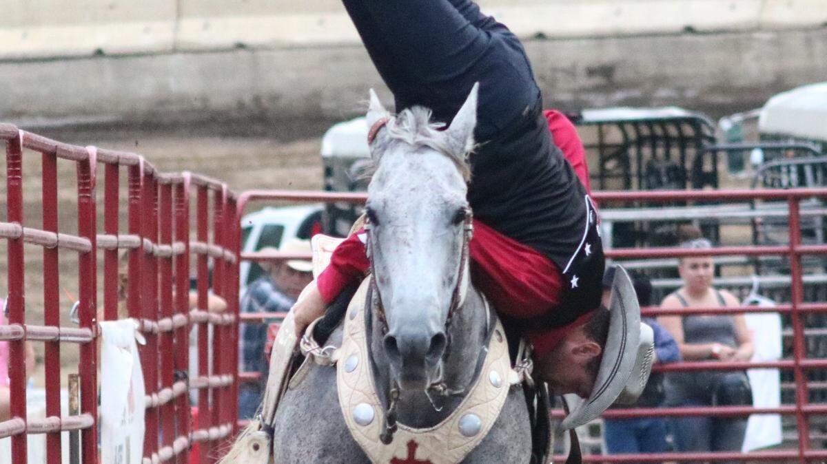 Trick-rider Justin Dickerson goes vertical while riding his horse in the rodeo during the Madison County Fair.