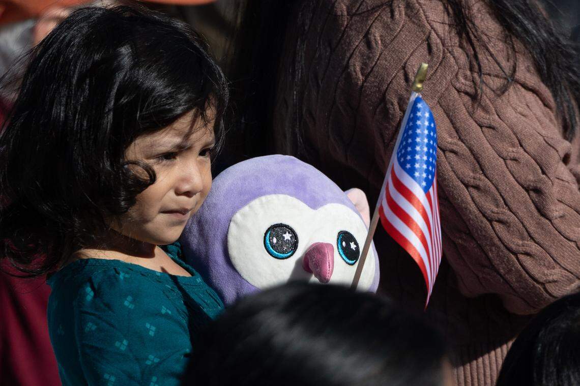A child holds an American flag along with her stuffy during Belleville’s 26th annual Veterans Day ceremony on Nov. 11, 2024.