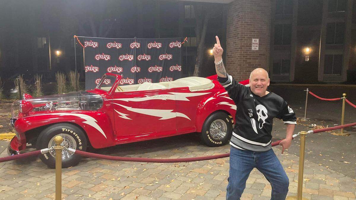 A fan with the Greased Lightning car at a Greaseville USA event.