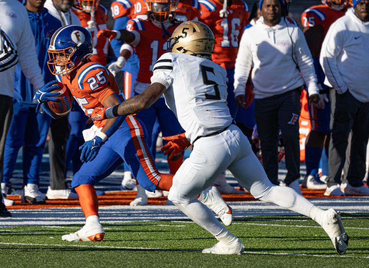 East St. Louis’ Amir Tilman (25) carries the ball while under pressure during the Flyers’ Class 6A semifinal win over Oak Lawn Saturday.