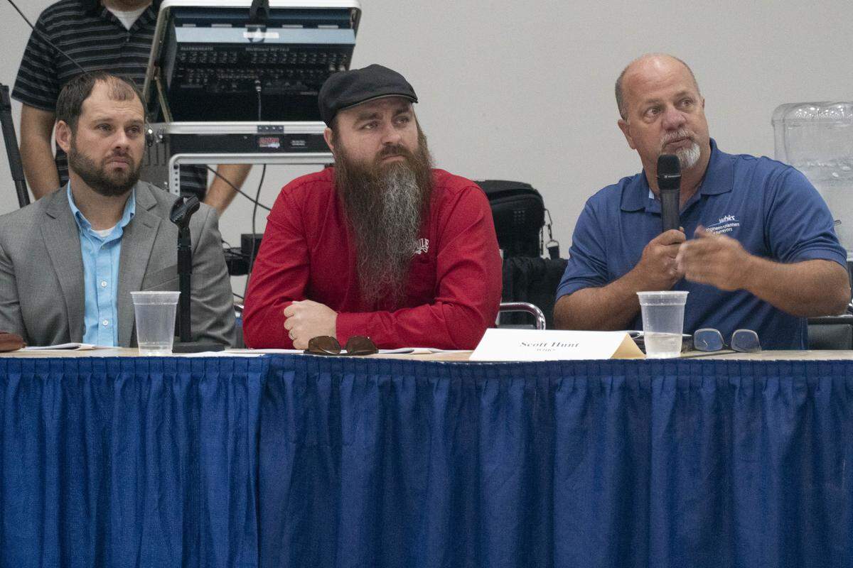 Scott Hunt, right, speaks during Tuesday night’s city council meeting, while Troy Turner and Michael Crawford listen.