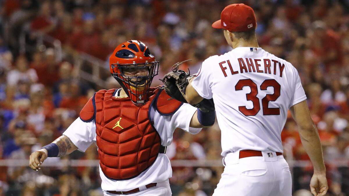 St. Louis Cardinals catcher Yadier Molina, left, congratulates starting pitcher Jack Flaherty after a strike out ends the top half of the fifth inning of a baseball game against the Los Angeles Dodgers Friday, Sept. 14, 2018, in St. Louis, Mo.. (AP Photo/Billy Hurst)