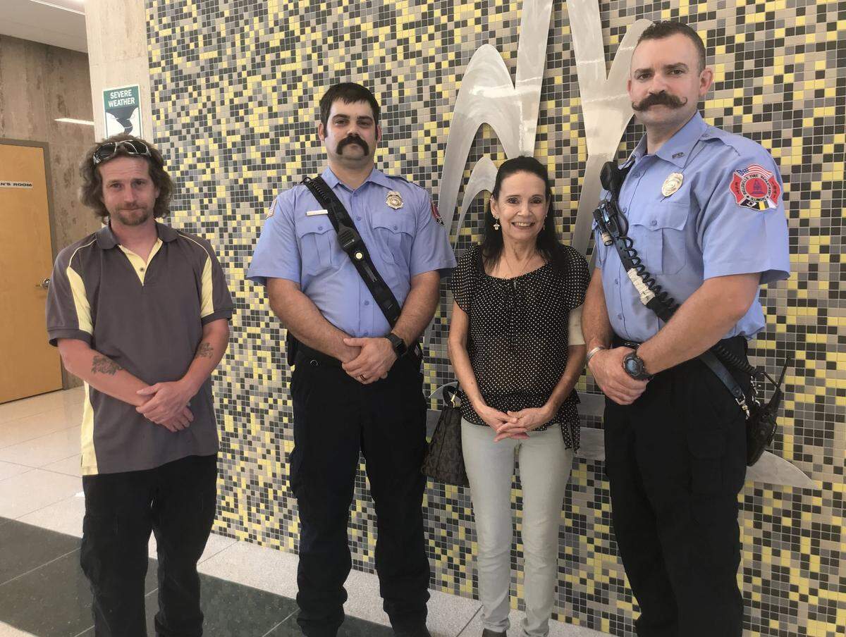Belleville firefighters Alex Kuhl, second from left, and Ryan Mahoney, who rescued toddler Malcolm Tompkins from a house fire in January, pose for photos with his great-grandmother, Dee Turnbeaugh, and great-uncle Bradley Smith after a Belleville City Council meeting Tuesday night.