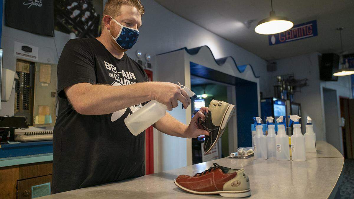 Dale Strom cleans a pair of bowling shoes at Bel-Air Bowl on June 26. The bowling alley reopened for the first time on Friday since the coronavirus closed businesses across the region.