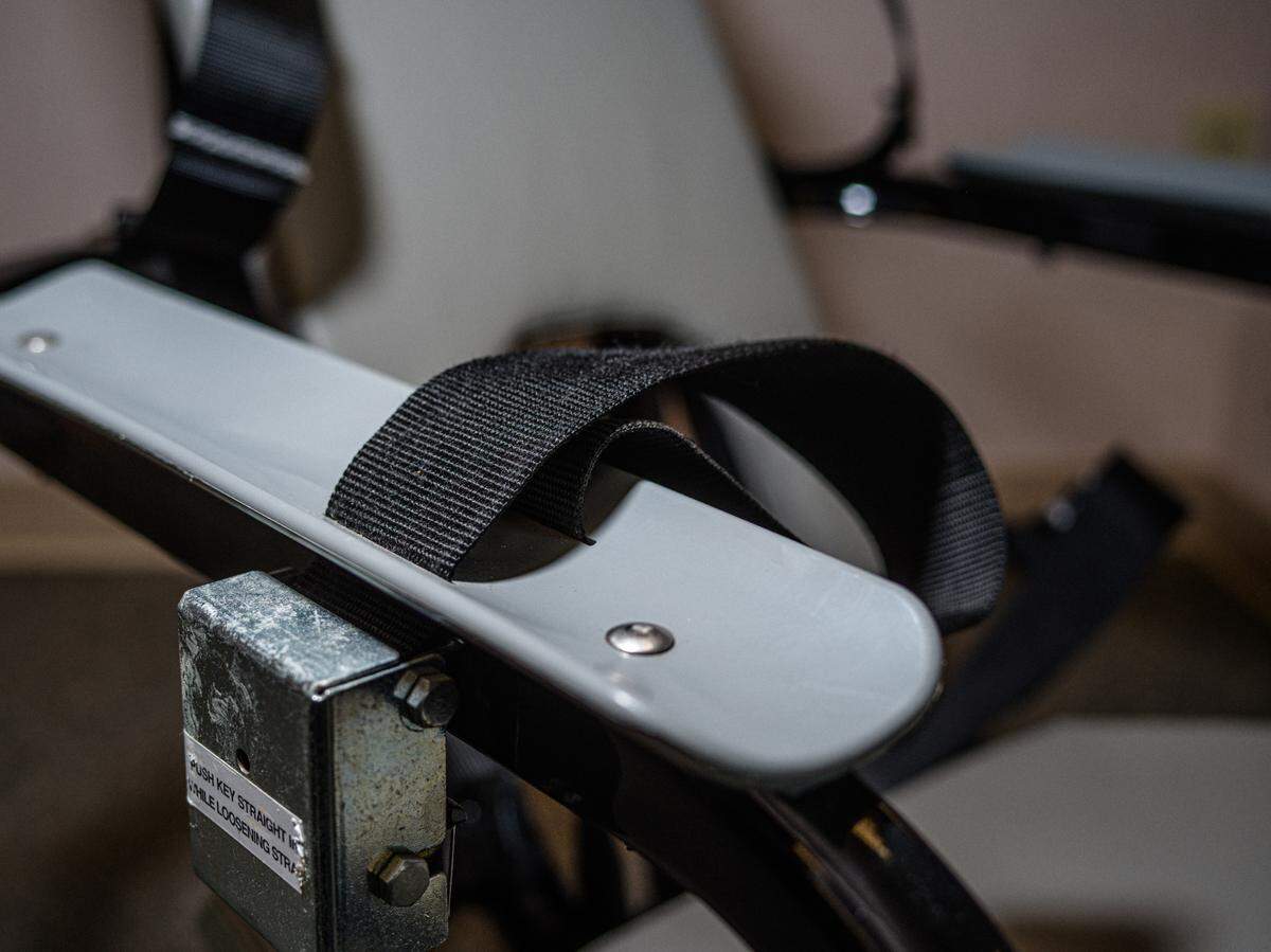 A restraint chair made by E.R.C. Inc. can be seen. The company, now known as Safety Restraint Chair Inc., previously faced scrutiny for the use of its chairs at Guantánamo Bay.
