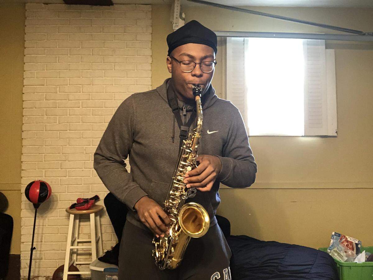 Jaylon Muchison, a senior at Belleville West High School, has been practicing alto sax in his garage, even though he may never play with the Honors Symphonic Band again.