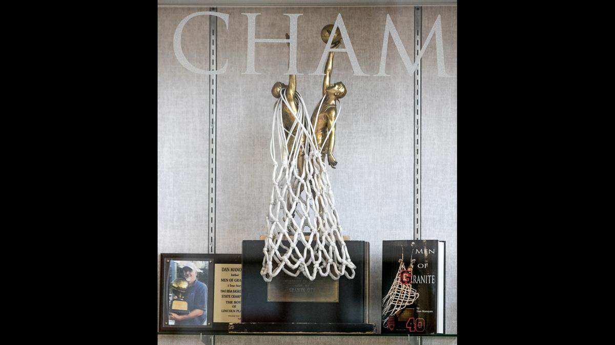 The state championship trophy won by the Granite City High School basketball team in 1940 is draped with a net and prominently displayed in the lobby of the school gym.