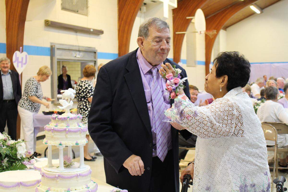 Julie Hubbard feeds wedding cake to her new husband, Joe Hubbard, at their reception in the parish hall at St. Henry's Catholic Church in Belleville.