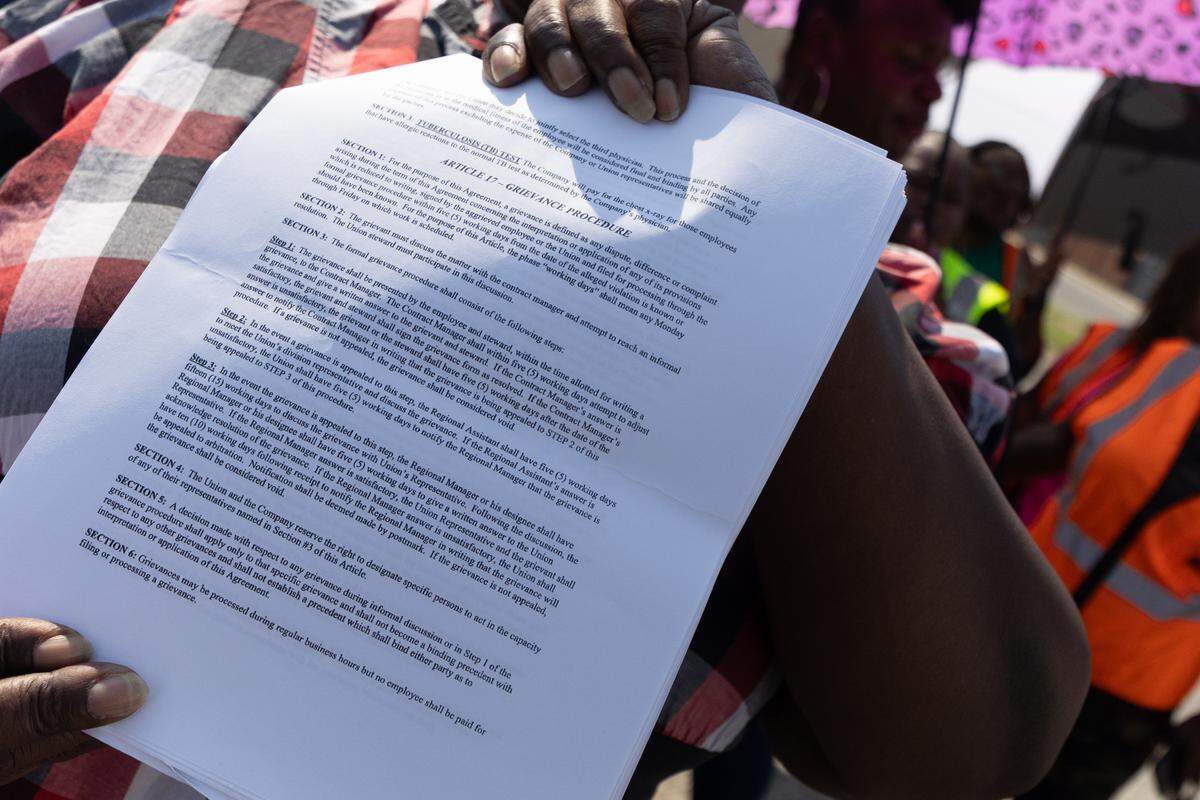 Schwann Marcano, a bus driver for Illinois Central School Bus, holds a copy of her contract during a protest to air grievances against her employer.