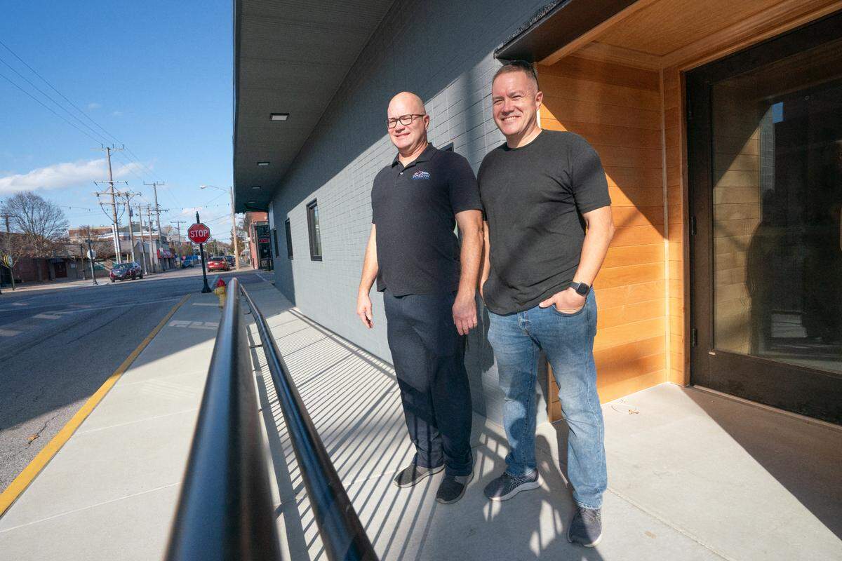 Vic and Karl Gilpin stand in front of the old Schaufler’s Pharmacy building at 300 E. Main St. in Belleville last year. They converted it into loft apartments.