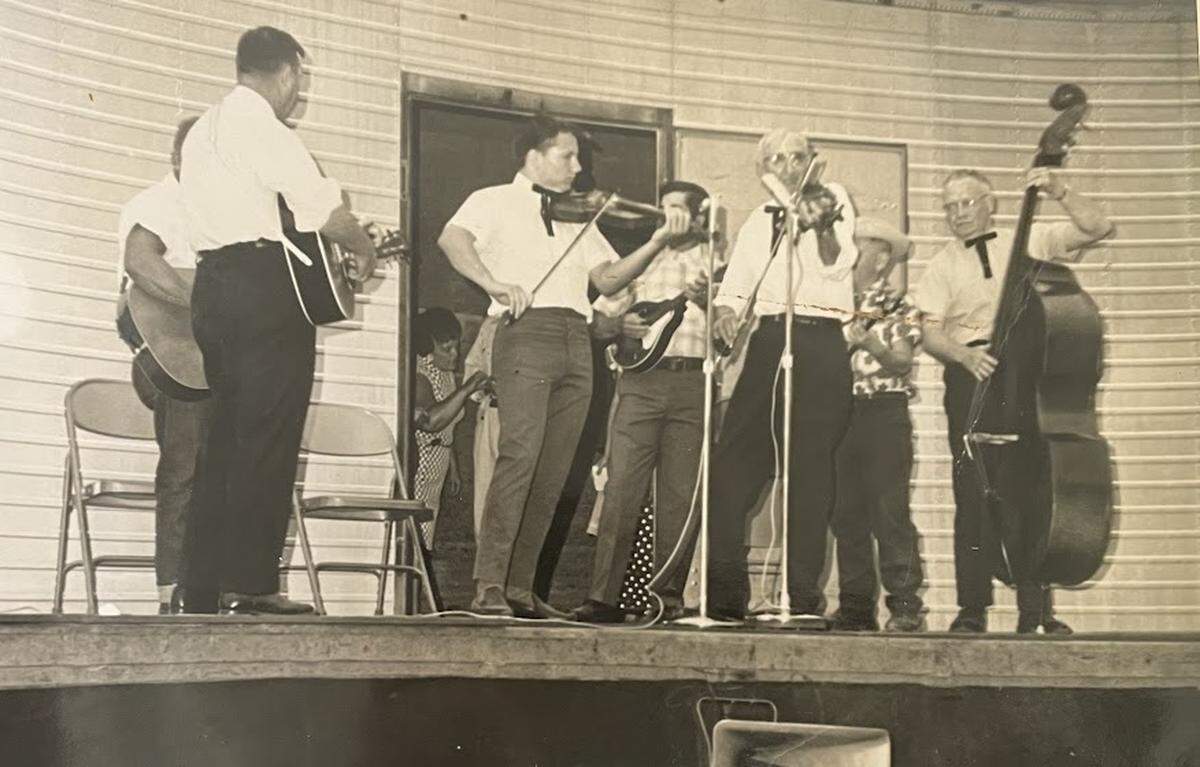 Sixteen-year-old George Portz, center left, takes the stage with his grandfather, Perry Biggs, center right, and other musicians at the Illinois open fiddle championships in 1969.