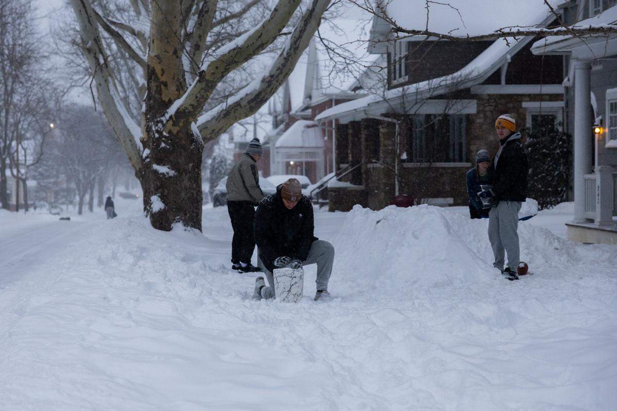 Penn State students build a snow fort on their front lawn off of West College Avenue on Sunday in State College.