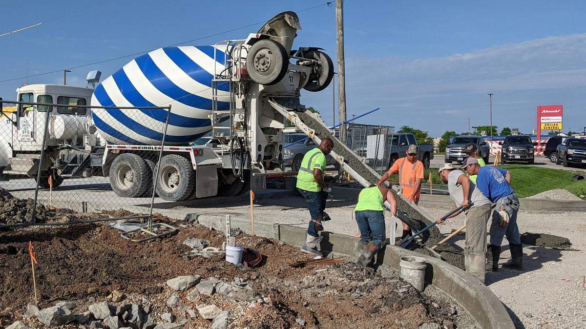 Crew members start pouring cement at the entrance of the McDonald’s parking lot in East Belleville.