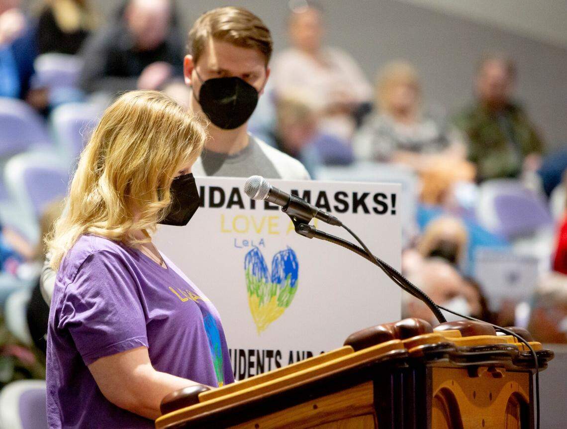 Stephanie Biondi, an English teacher at Collinsville High School, speaks in favor of keeping mask requirements in schools last month as her husband, Jacob Post, who teaches special education at the high school, stands behind her.