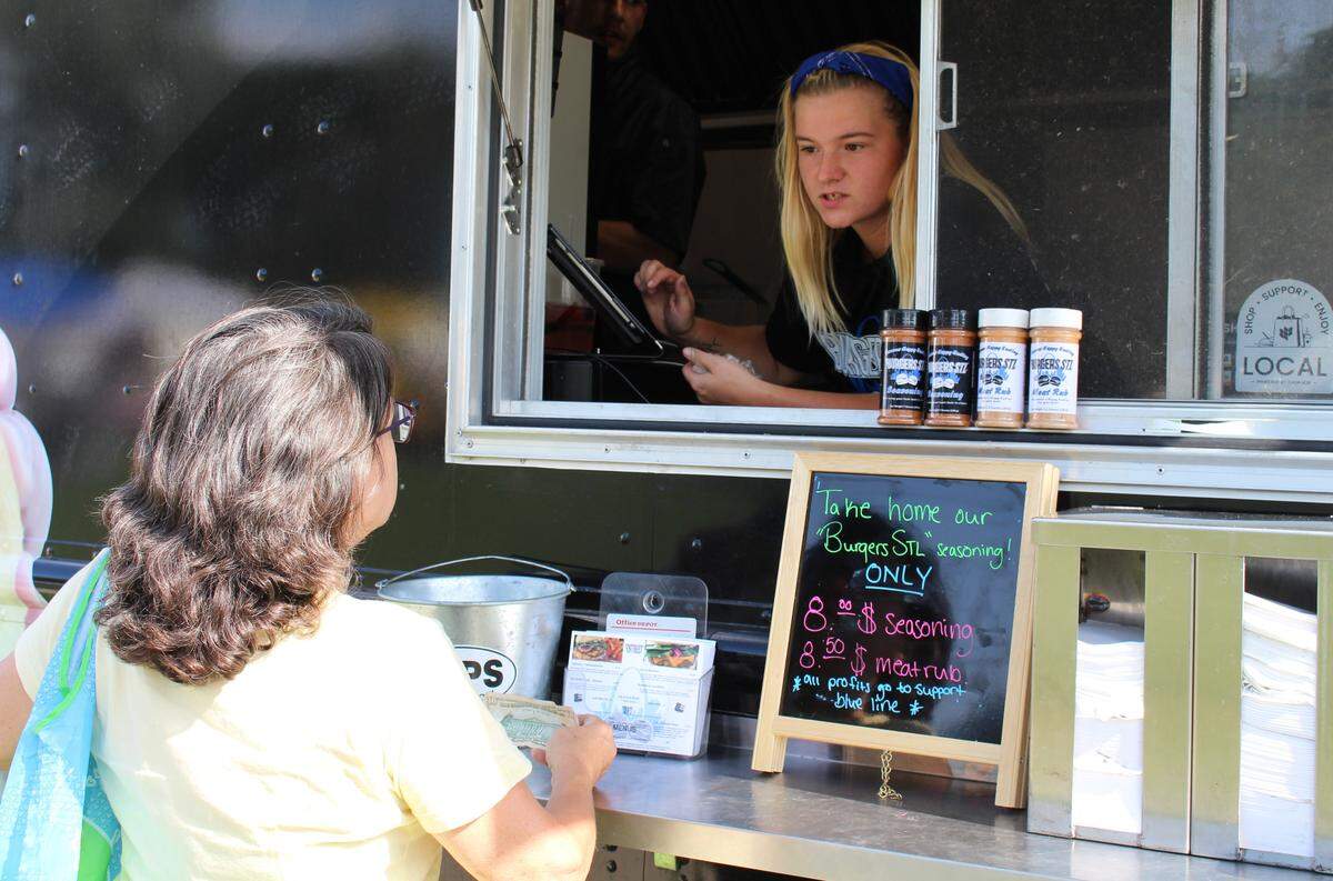 Chloe Brown, right, an employee with the Burgers STL food truck, takes an order from Francie Collins at Maryville Farmers Market, which operates one day a month in Collinsville.