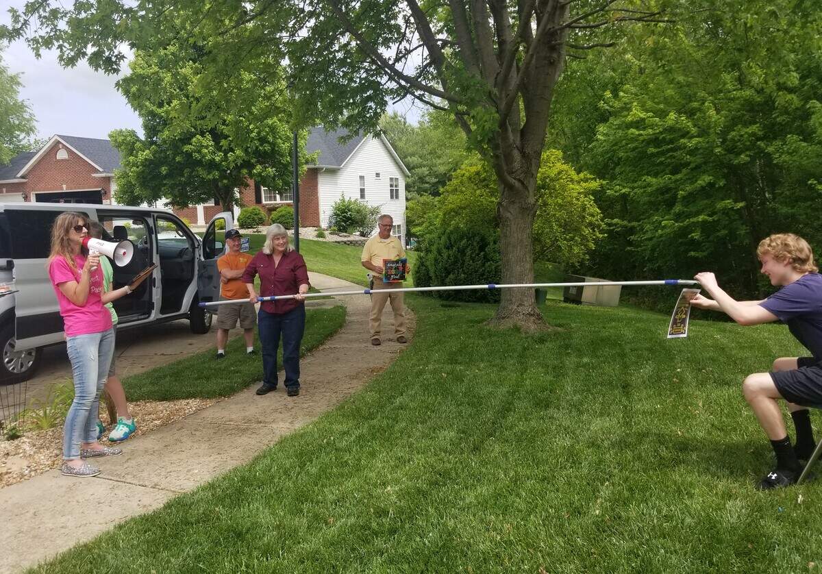 Members of Eden Church in Edwardsville recognize the graduation of Justin Folmer with a diploma on the end of a pole as part of social-distancing efforts.