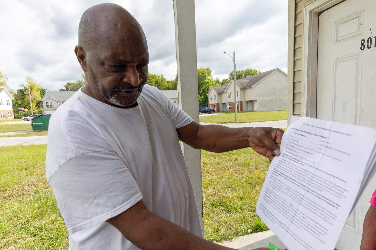 Barry Bagley has lived at Centreville Courts with his wife Tracy Smith for six years. Bagley holds up a notice that the apartment owner, a northern Illinois nonprofit housing organization called The Burton Foundation, sent to all tenants on Sept. 16, 2024. The notice told them they had 60 days to leave their homes because the complex was closing for financial reasons. Within a matter of weeks, The Burton Foundation rescinded the notice and said it would make needed repairs to the buildings. Bagley and Smith have been on a waiting list with the St. Clair County Housing Authority for a new apartment since August because of the lack of maintenance at Centreville Courts.