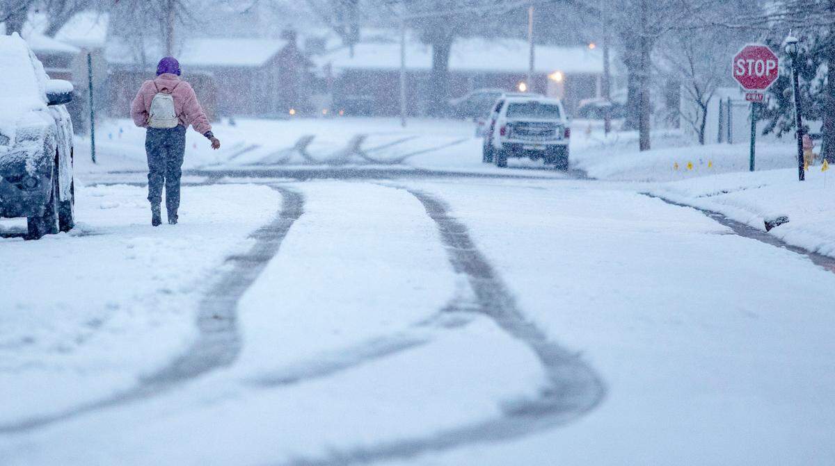 A person walks down Cherry Drive in Fairview Heights on Wednesday morning as a light snow falls on the region. The winter storm that hit the metro-east was far less problematic than originally projected.