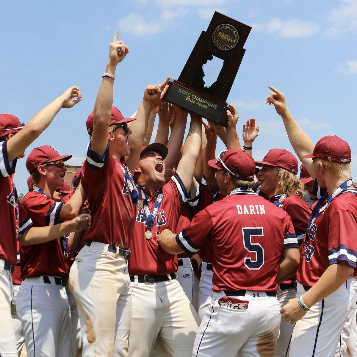 Gibault players celebrate with the championship trophy after defeating Henry H-Senachwine 8-0 in Saturday’s IHSA Class 1A state championship game at Dozer Park in Peoria. The win secured the second state championship in the baseball program’s history.
