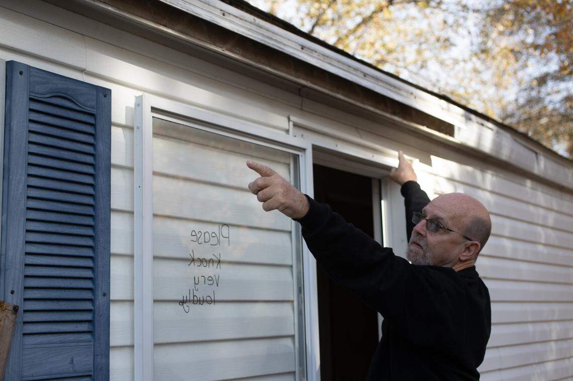 Greenmount Station resident Jim Hodgkins points to where an awning on his rented mobile home was taken out by a storm in 2024.