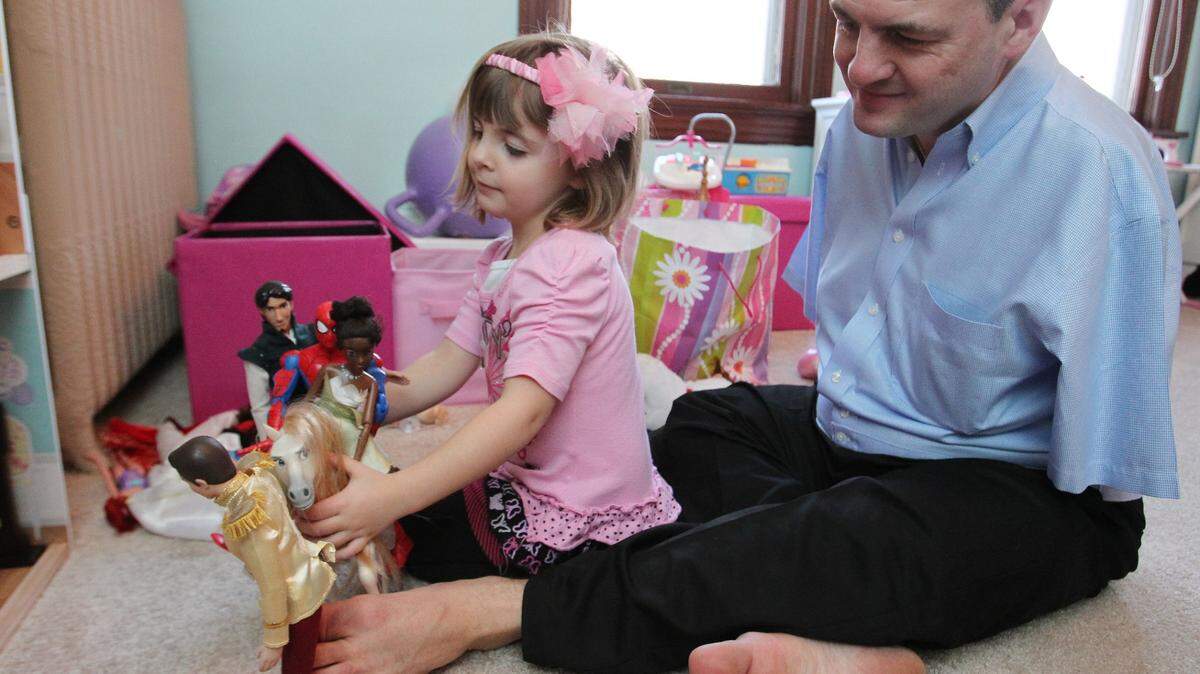 John Foppe, a Breese man who was born with no arms, uses his feet to play with his 4-year-old daughter, Faith.