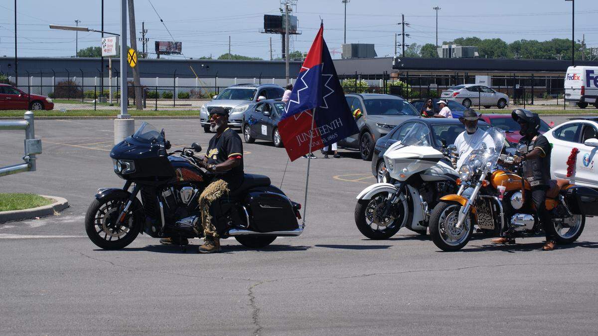 A motorcyclist with a Juneteenth flag on his bike waits for the Juneteenth motorcade to begin Saturday in a MetroLink parking lot in downtown East St. Louis.