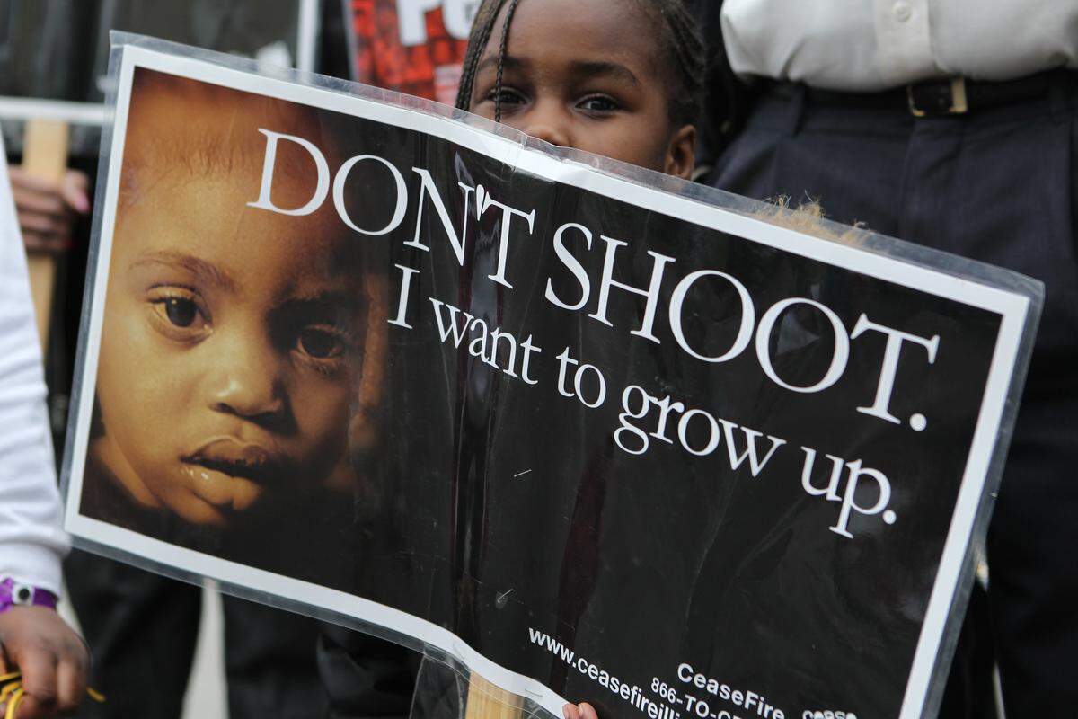 A child holds a sign during an East St. Louis cease fire rally.